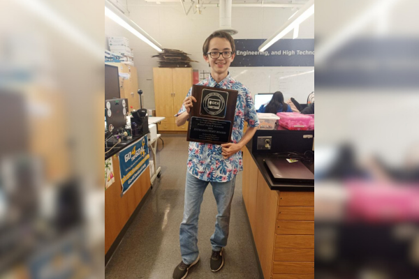  A boy holds a plaque in a classroom